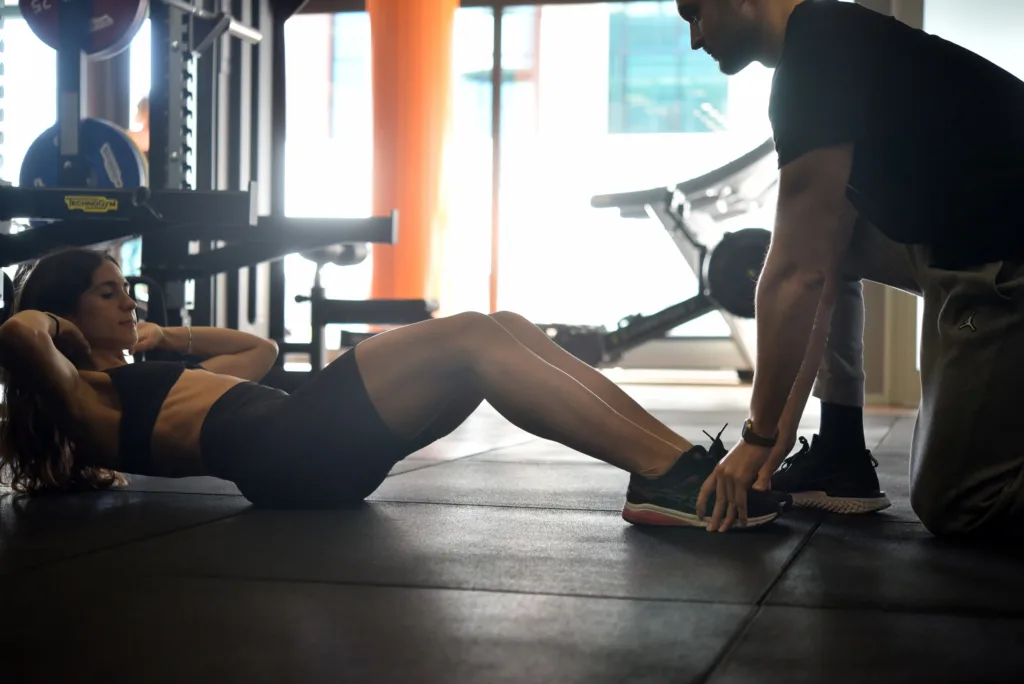 Giorgio De Conto, personal trainer, assiste cliente durante esercizio a terra